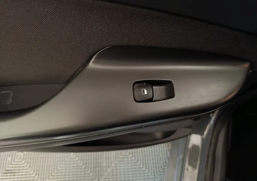 Gros plan sur le bouton de verrouillage des portes côté gauche d'une Hyundai Kona gris foncé, version hybride 2023.