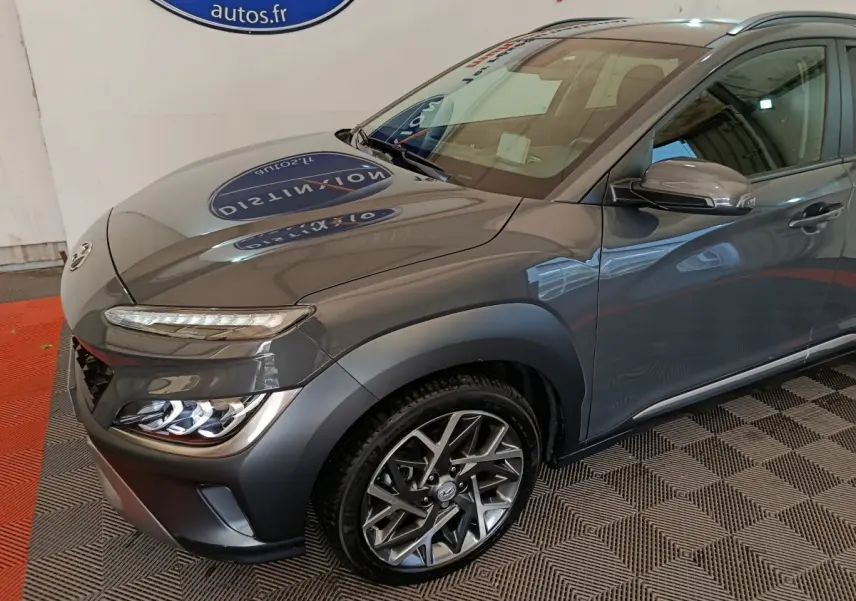 Vue 3/4 avant droit d'un Hyundai Kona gris foncé mettant en valeur ses phares LED et ses jantes alliage au design moderne.