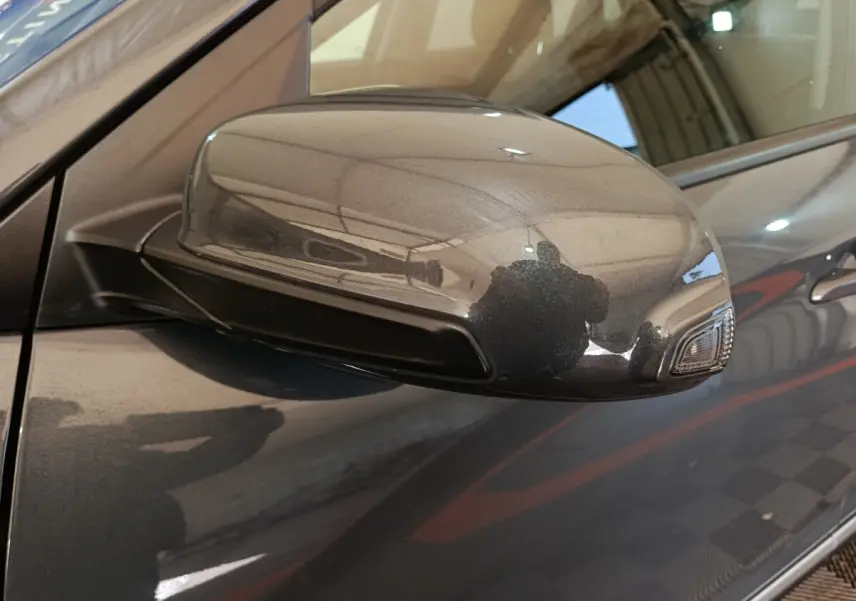 Rétroviseur droit gris foncé du Hyundai Kona 1.6 Hybrid 2023 avec clignotant intégré, vue rapprochée côté passager.
