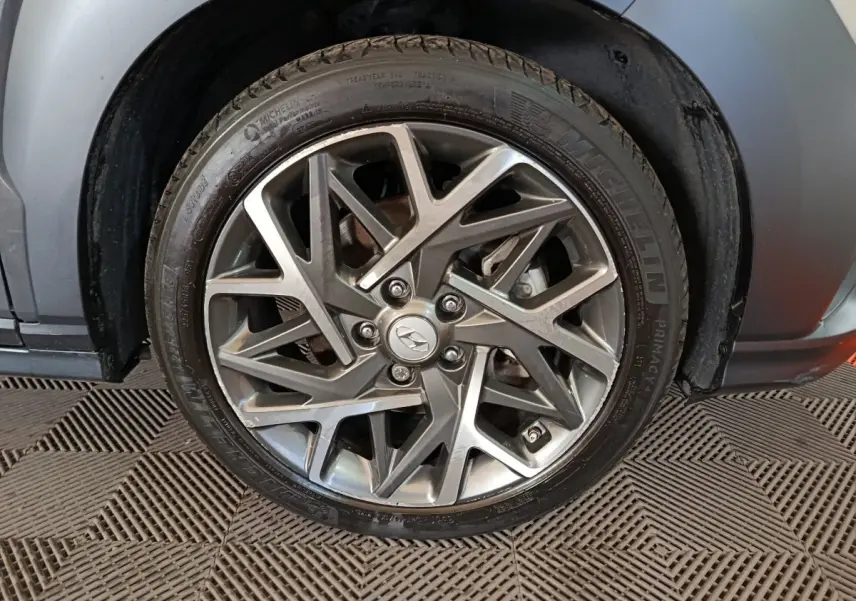 Gros plan sur la jante alliage grise au design géométrique du côté arrière droit d’un Hyundai Kona gris foncé.