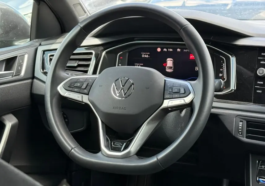 Vue rapprochée du volant cuir multifonction et du tableau de bord numérique du Volkswagen Taigo gris 2025.