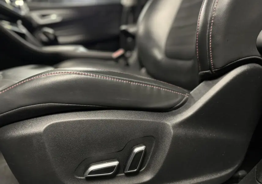 Gros plan sur le siège avant conducteur en cuir noir avec surpiqûres rouges du MG Motor EHS 2022.