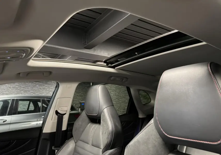 Vue intérieure du toit ouvrant panoramique et sièges avant cuir noir avec surpiqûres rouges du MG MOTOR EHS noir 2022.