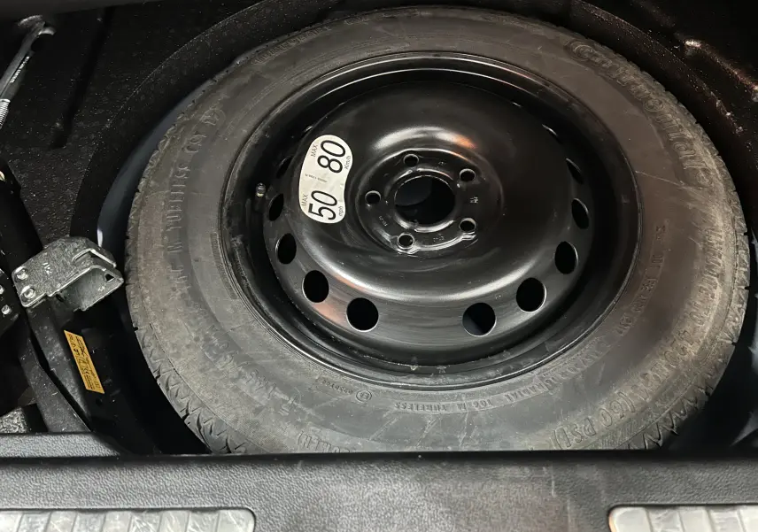 Gros plan sur la roue de secours noire avec étiquette de vitesse dans le coffre d'un Renault Kadjar bleu 2017.