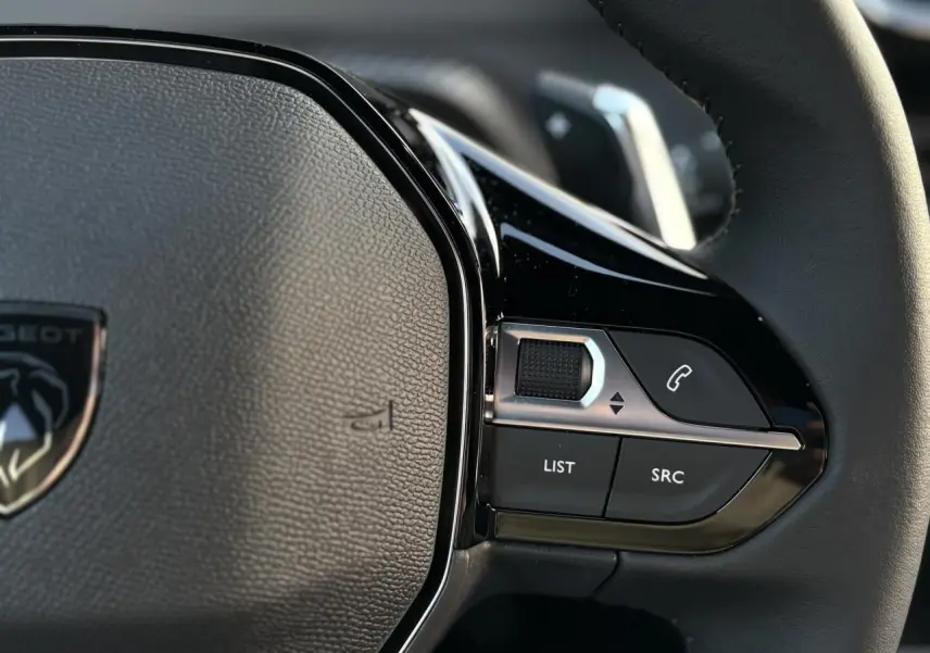 Gros plan sur les commandes multimédia à droite du volant cuir du Peugeot 2008 Hybrid 145 e-DSC6 Allure.