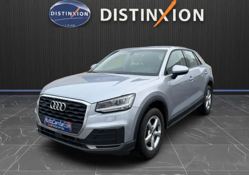 Audi Q2 gris aluminium en 3/4 avant droit, avec calandre noire et jantes alliage 5 branches visibles.