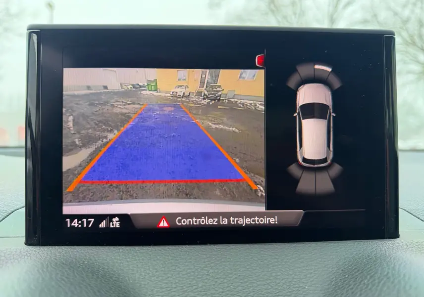 Écran de caméra de recul et vue 360° du tableau de bord de l'Audi Q2 gris aluminium en stationnement.