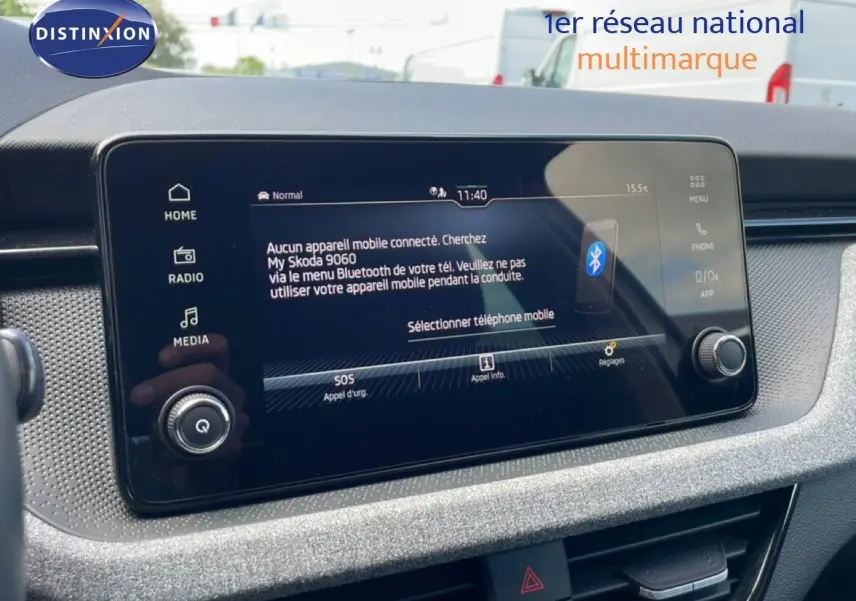 Écran tactile central de la Skoda Scala blanc glacier, vue rapprochée du tableau de bord avec interface Bluetooth affichée.
