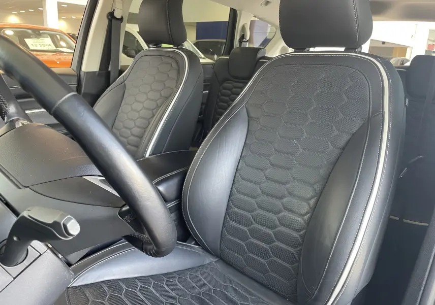 Vue intérieure sur les sièges avant en cuir noir avec surpiqûres blanches du Ford S-MAX Vignale 2022, détails hexagonaux visibles.