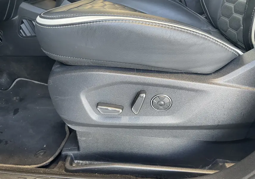 Gros plan sur les commandes électriques du siège avant gauche en cuir noir avec surpiqûres blanches du Ford S-MAX Vignale gris magnetic 2022.