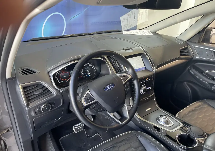 Vue intérieure côté conducteur du Ford S-MAX Vignale 2022 gris, avec tableau de bord numérique et console centrale tactile.