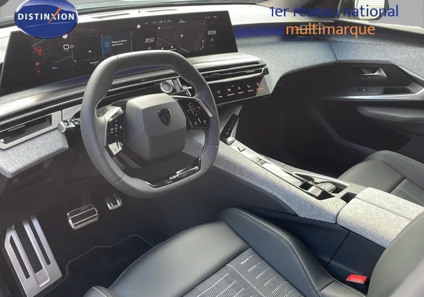 Intérieur moderne du Peugeot 3008 2025, vue côté conducteur, avec volant compact et sellerie cuir noir et tissu gris.