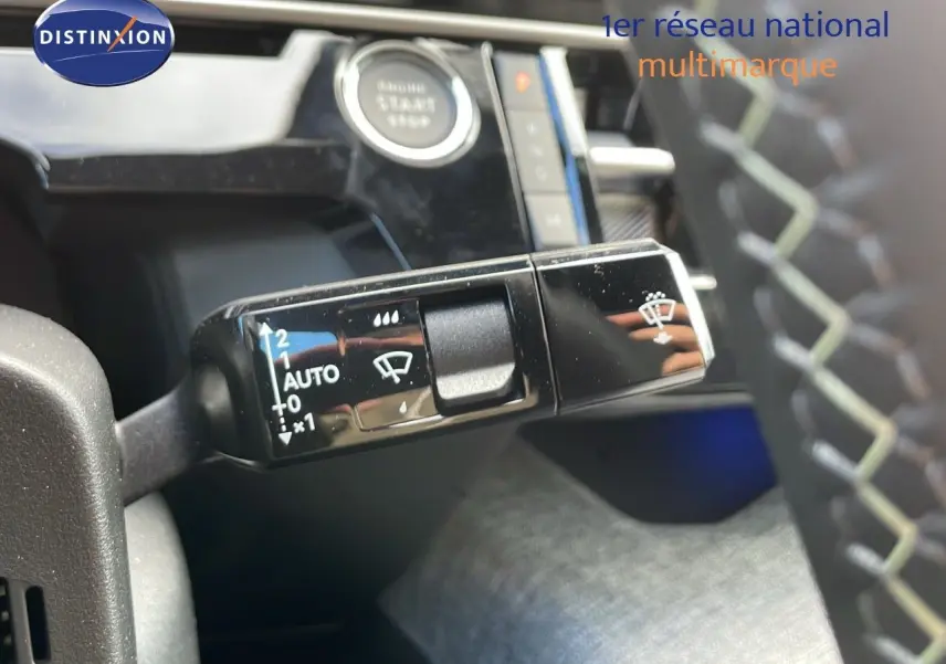 Gros plan sur la commande d'essuie-glace à gauche du volant dans l'habitacle du Peugeot 3008 hybride 2025.