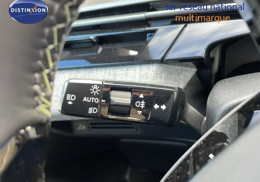 Gros plan sur la commande des phares et clignotants du Peugeot 3008 hybride 2025, intérieur noir et détails chromés.