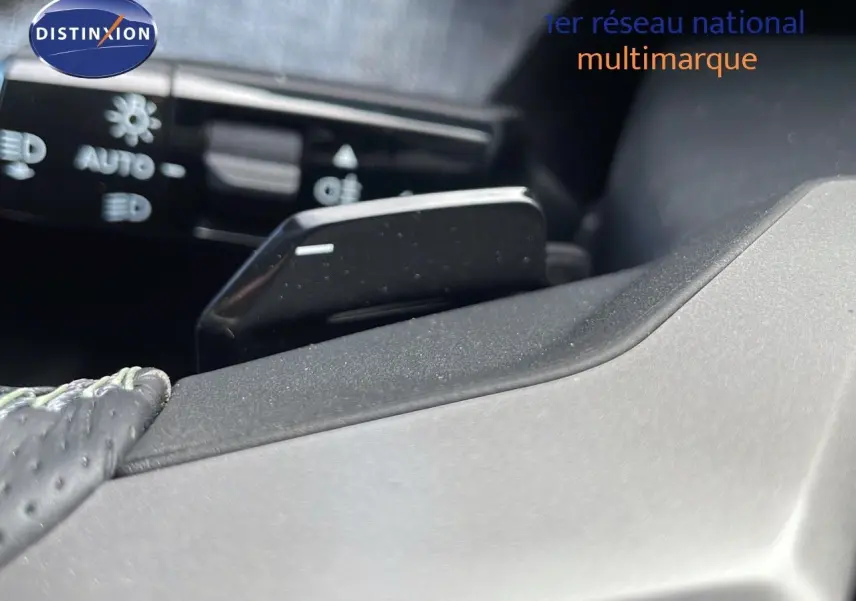 Gros plan sur la palette de commande au volant d’un Peugeot 3008 hybride 2025 avec cuir noir perforé.