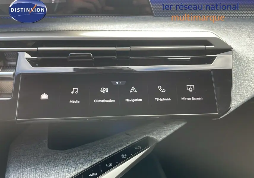 Tableau de bord du Peugeot 3008 hybride 2025 avec écran tactile central et commandes climatisation visibles.