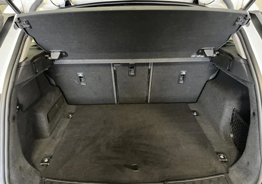 Coffre ouvert du Range Rover Evoque blanc 2020, montrant un espace de chargement propre et bien aménagé.