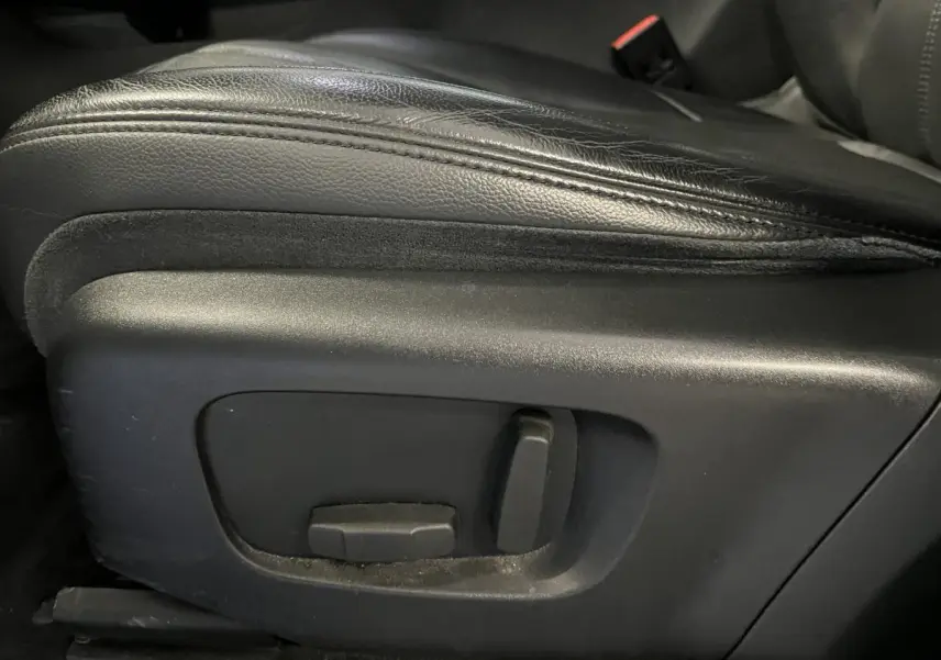 Gros plan sur les commandes électriques du siège avant en cuir noir du Range Rover Evoque blanc de 2020.