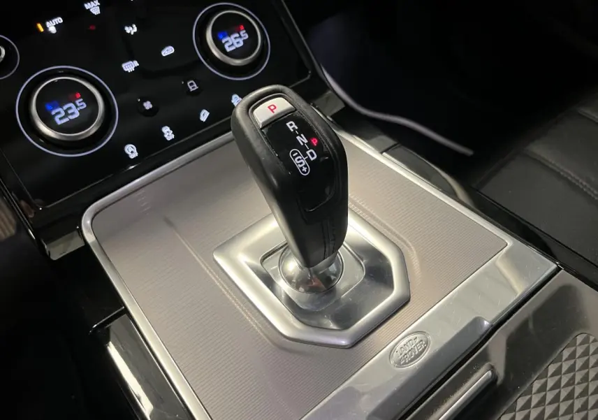 Le levier de vitesses automatique noir et argenté du Range Rover Evoque 2020, avec commandes de climatisation en arrière-plan.