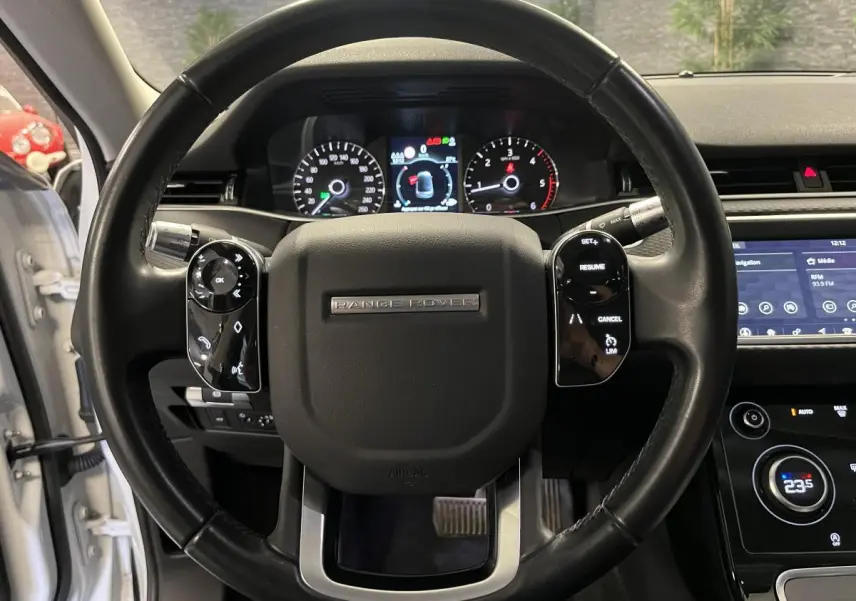 Vue rapprochée du volant cuir noir du Range Rover Evoque 2020 avec commandes intégrées et tableau de bord numérique.