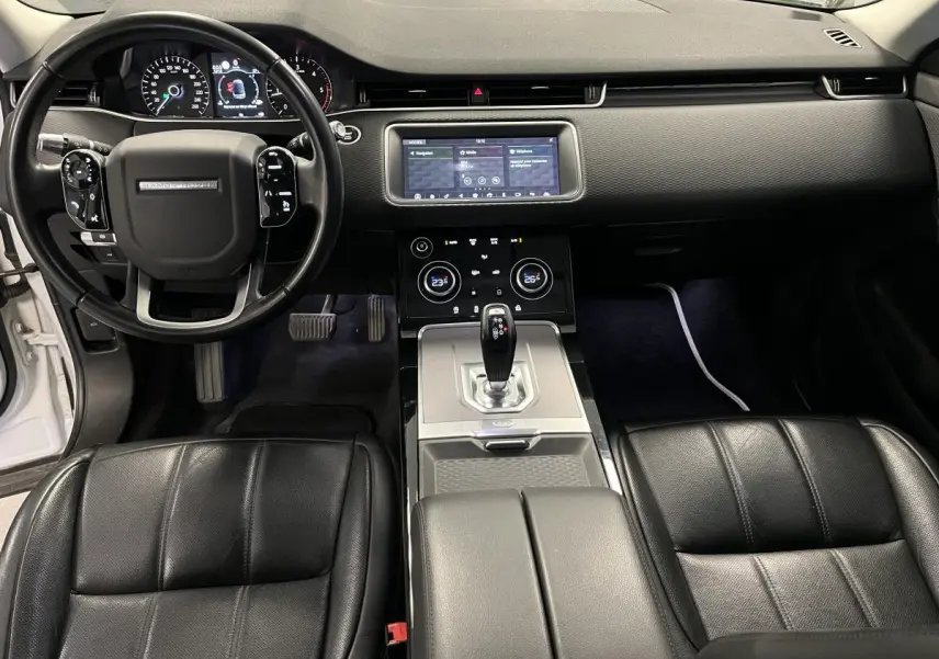 Intérieur noir du Range Rover Evoque 2020 vu de face, avec tableau de bord digital et console centrale moderne.