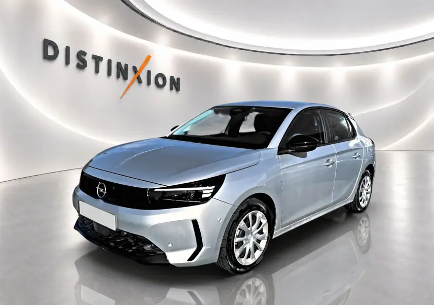 Opel Corsa gris alu vue 3/4 avant droit dans un showroom lumineux avec logo Distinxion en arrière-plan.
