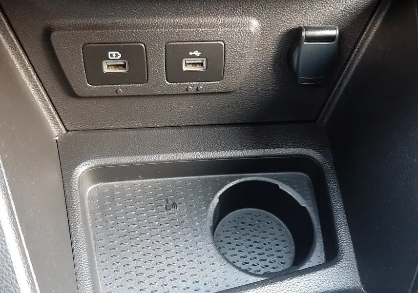 Vue rapprochée de la console centrale du Dacia Duster 2023, montrant deux ports USB et un emplacement porte-gobelet noir.