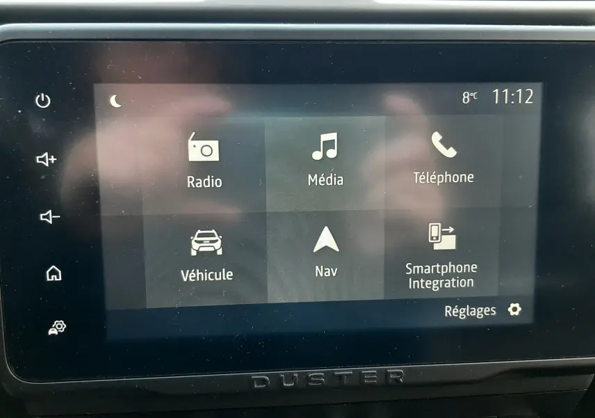 Écran tactile central du Dacia Duster 2023 affichant les options Radio, Média, Téléphone, Véhicule, Navigation et Smartphone Integration.