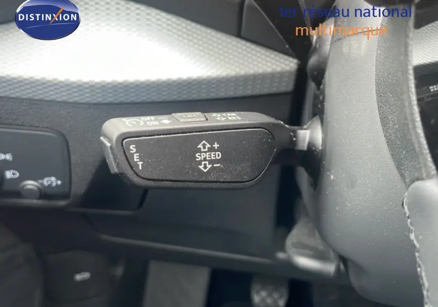 Gros plan sur la commande de régulateur de vitesse à gauche du volant d’un Audi Q2 noir Mito Metal 2025.