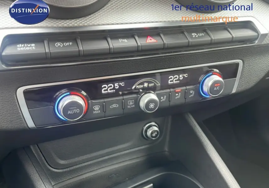 Vue rapprochée du tableau de bord de l'Audi Q2 30 TDI S-Line 2025, montrant la climatisation digitale et les commandes.