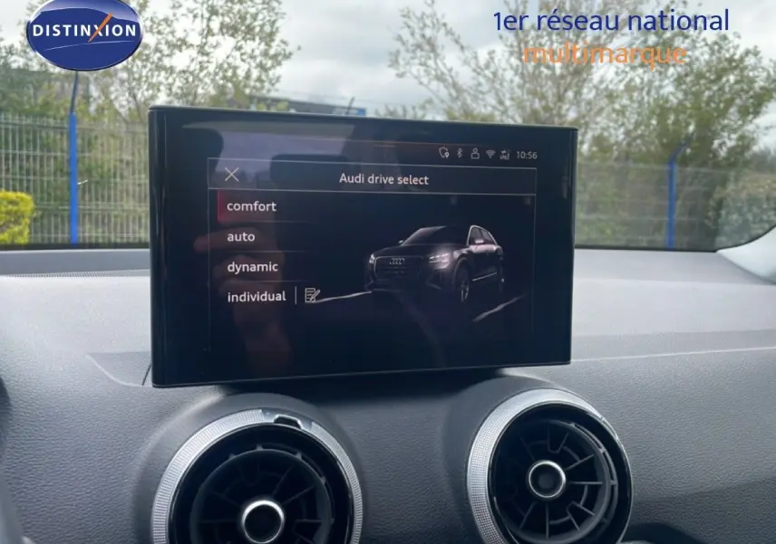 Écran central affichant les modes de conduite de l'Audi Q2 30 TDI S-Line, intérieur noir, vue du tableau de bord.