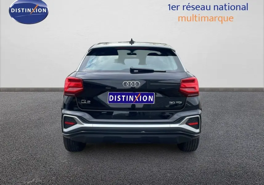 Vue arrière d'un Audi Q2 30 TDI S-Line noir mito metal avec feux rouges et détails chromés sur pare-chocs.