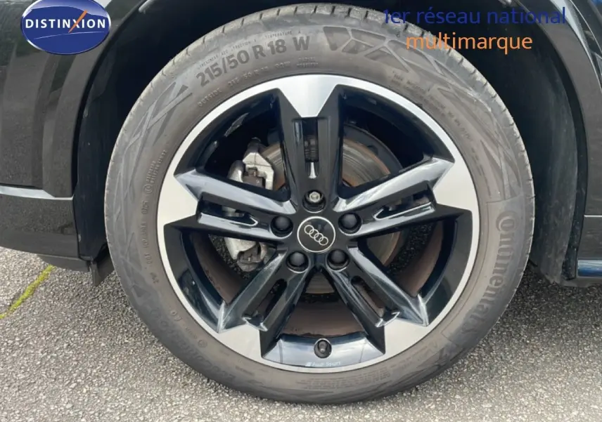 Gros plan sur la jante noire et argentée Audi Sport de l'Audi Q2 30 TDI S-Line noir mito metal, avec pneu Continental.
