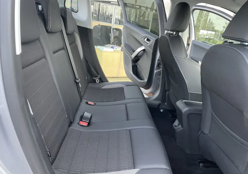 Vue intérieure côté gauche des sièges arrière en tissu noir et gris du Peugeot 2008 1.2 110 Allure 2019 avec porte arrière ouverte.