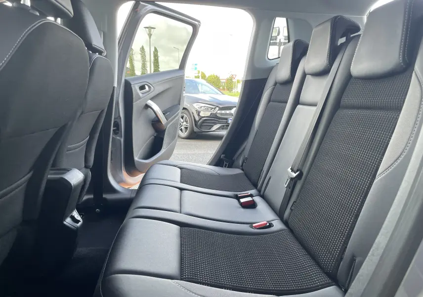 Vue intérieure sur la banquette arrière en tissu gris noir du Peugeot 2008 2019 avec porte arrière ouverte côté gauche.
