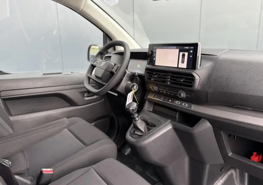 Intérieur du Peugeot Expert Fourgon 2025 vu côté conducteur, avec tableau de bord noir et écran tactile 10 pouces.