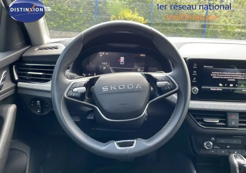 Vue intérieure centrée sur le volant noir de la Skoda Scala 2025, avec tableau de bord digital et écran tactile.