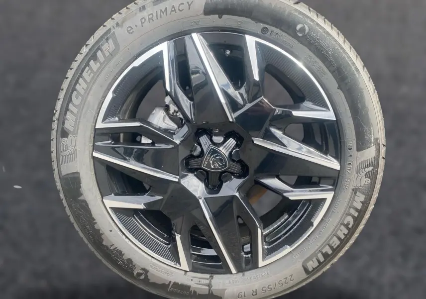 Gros plan sur la jante alu noire et argentée d’un Peugeot 3008 Bleu Obsession avec pneu Michelin.