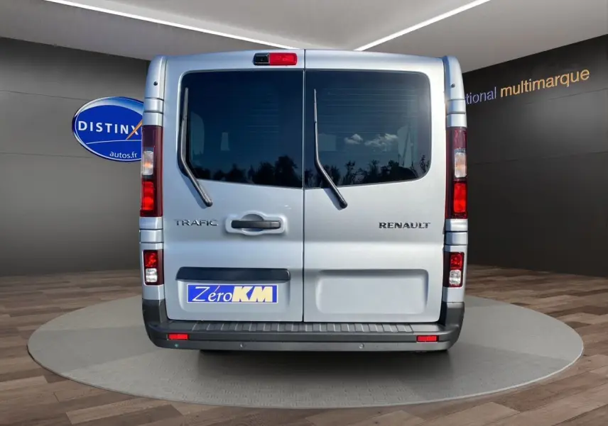 Vue arrière du Renault Trafic Combi gris Highland avec portes vitrées et essuie-glaces sur vitres arrière.