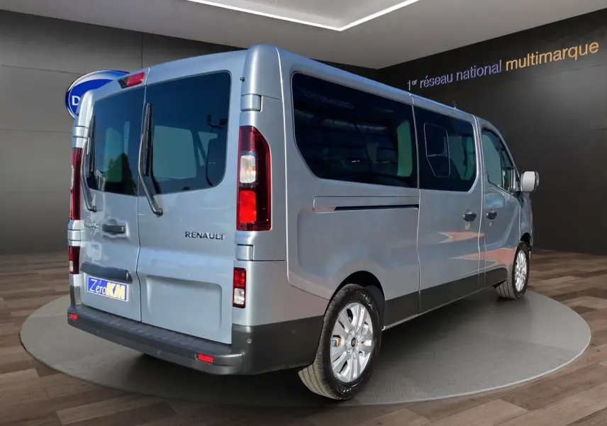 Renault Trafic Combi gris Highland vu en 3/4 arrière droit, portes arrière vitrées ouvertes à 180° visibles