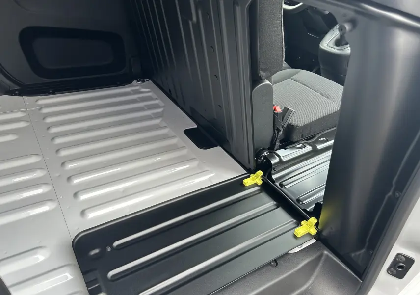 Vue intérieure du plancher arrière blanc et siège avant gris du Citroën Berlingo Fourgon BlueHDi 100 2025.