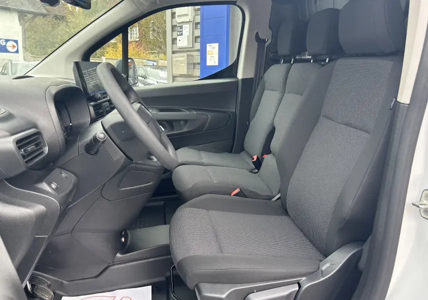 Intérieur du Citroën Berlingo Fourgon blanc 2025, vue côté conducteur montrant les sièges tissu et le tableau de bord.