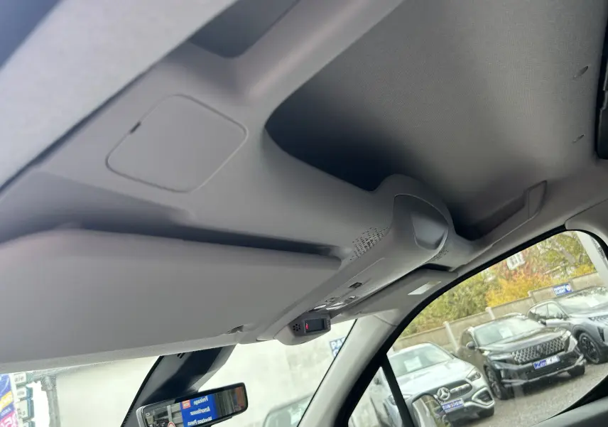 Vue intérieure du plafond et pare-soleil côté conducteur du Citroën Berlingo Fourgon blanc 2025 avec rétroviseur et contrôle intégré.