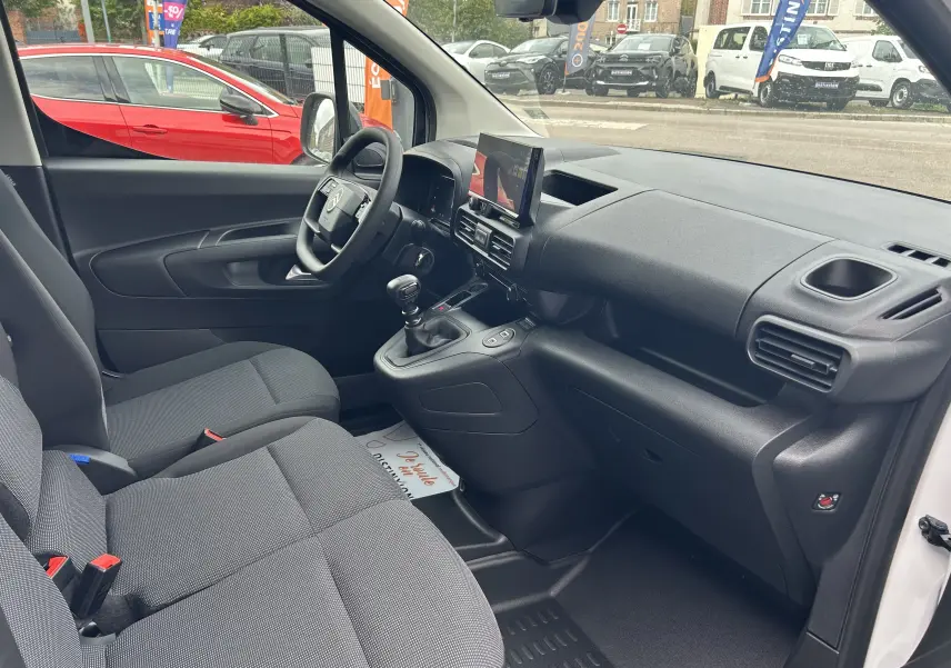 Intérieur avant du Citroën Berlingo Fourgon blanc 2025, vue côté conducteur avec tableau de bord et écran tactile central.