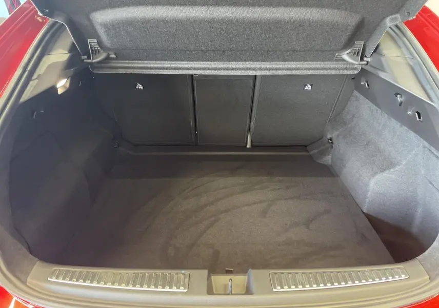 Coffre ouvert vu de l'arrière d'une Renault Rafale rouge avec toit noir, montrant l'espace de chargement vide.