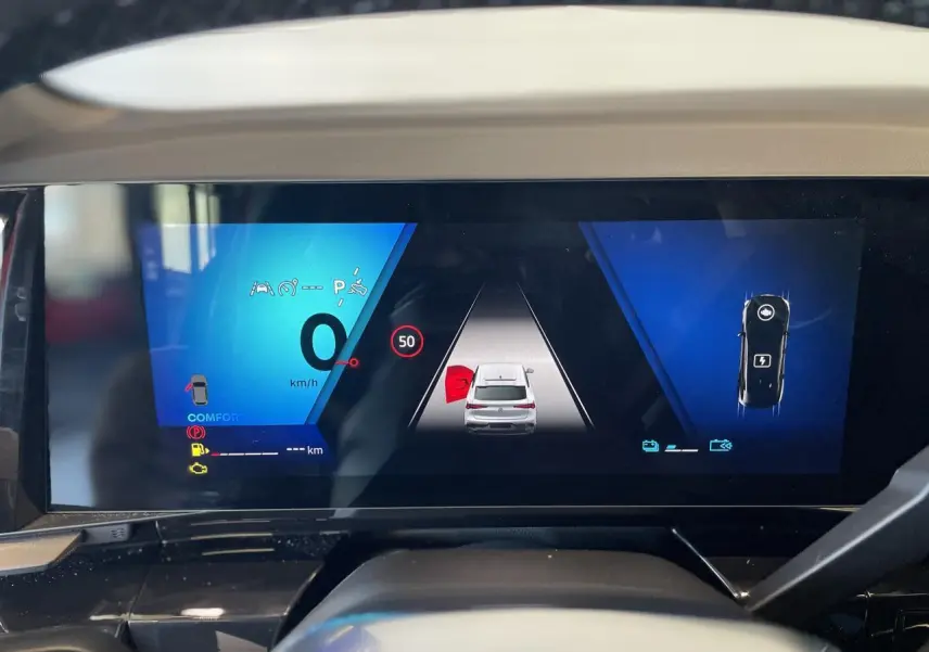 Tableau de bord numérique du Renault Rafale 2025 affichant la vitesse et l'aide au stationnement en vue frontale.