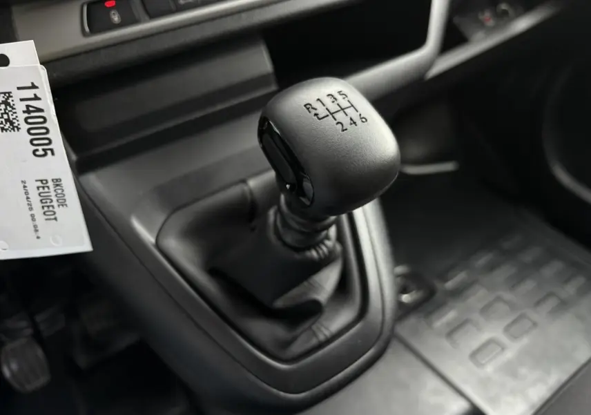 Gros plan sur le levier de vitesses manuel noir du Peugeot Expert Fourgon 2025, intérieur gris sombre.