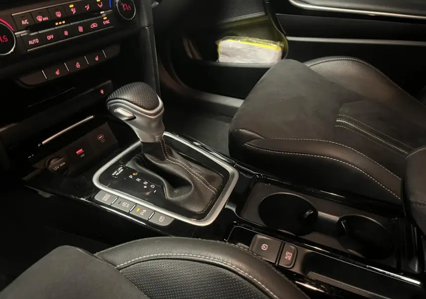 Gros plan sur la console centrale et levier de vitesses automatique de la Kia Ceed GT Line Premium 2023 en intérieur noir.
