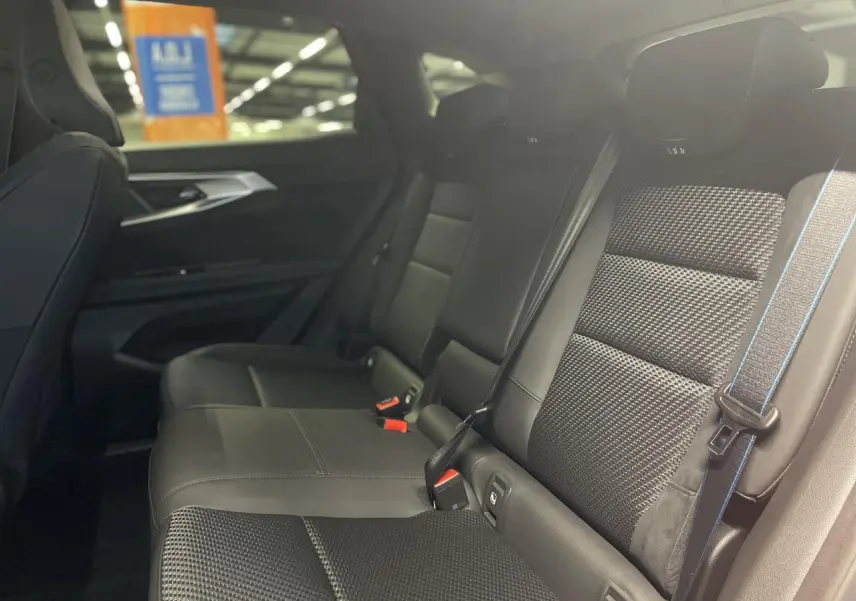 Vue latérale droite de la banquette arrière noire en tissu carbone et Alcantara avec surpiqûres tricolores dans un Renault Austral 2025.