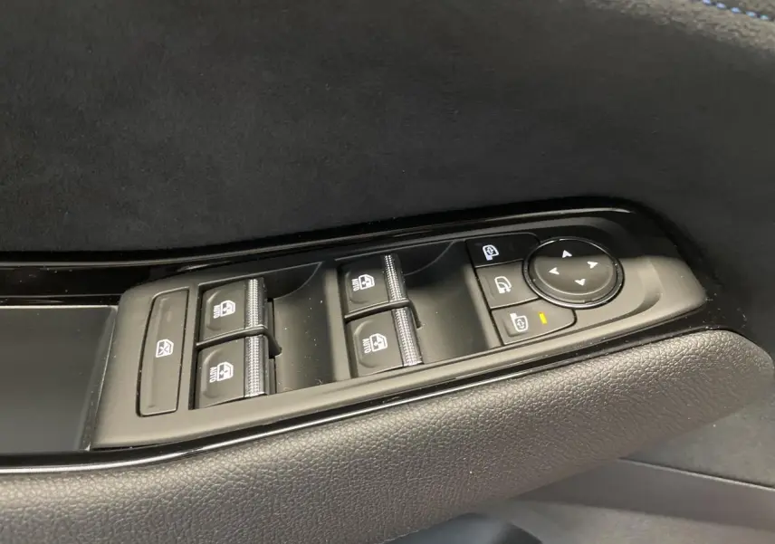 Gros plan sur les commandes de lève-vitres et rétroviseurs sur la porte côté conducteur du Renault Austral Esprit Alpine.